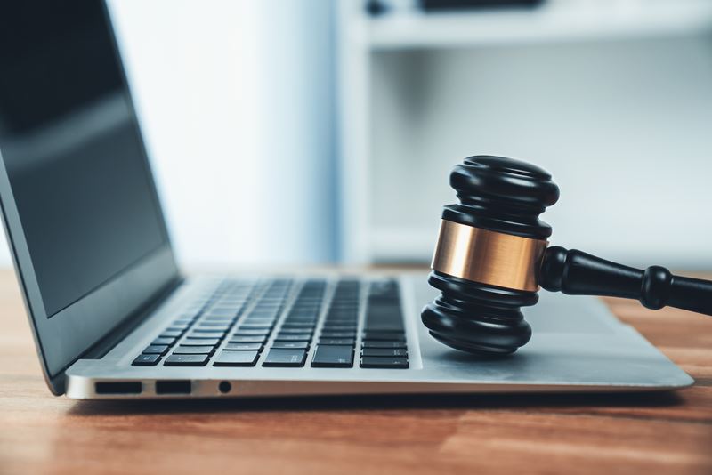 A judge's gavel is placed on a laptop